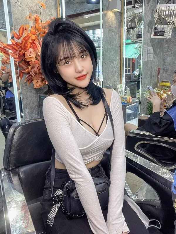 Tóc ngang lưng uốn đuôi chữ có một người phụ nữ ngồi bàn với ly rượu