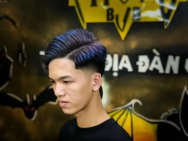Tóc side part nam có một người đàn ông với mái xanh đứng trước tường