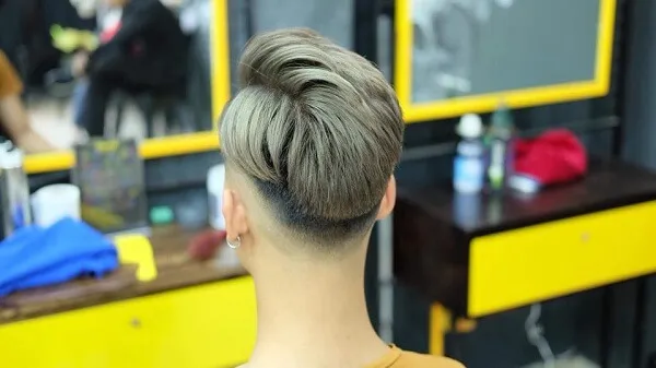 Tóc nam side part dài có một người phụ nữ đang cắt tại tiệm