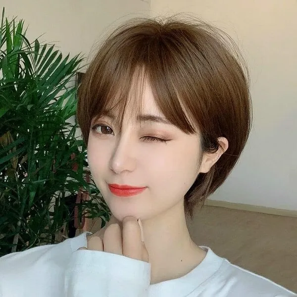Tóc tomboy có một người phụ nữ đang tạo ra bức tranh trong chiếc áo sơ mi trắng