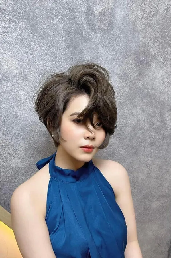 Tóc tomboy mullet có một người phụ nữ mặc chiếc váy màu xanh chụp ảnh