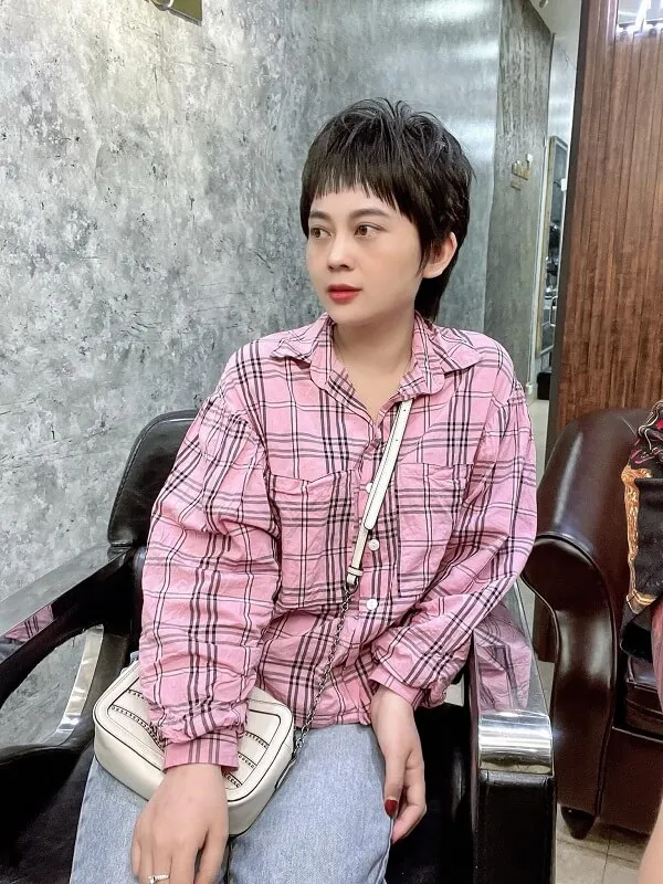 Tóc tomboy có một người đàn ông ngồi trên ghế mặc áo sơ mi màu hồng