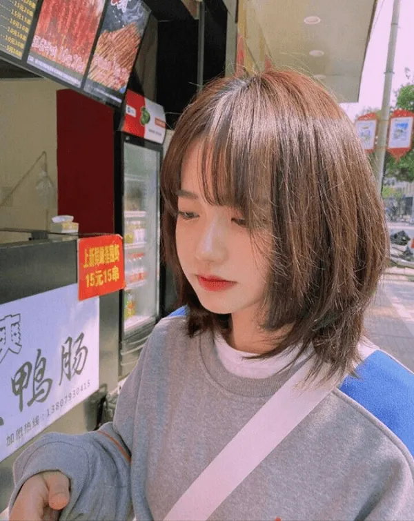 Tóc tomboy có một người phụ nữ đang đứng trước máy bán hàng tự động
