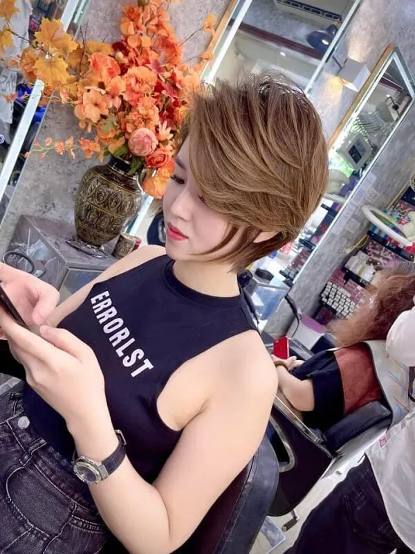 Tóc tomboy có một người phụ nữ đang nhìn vào điện thoại di động của cô ấy