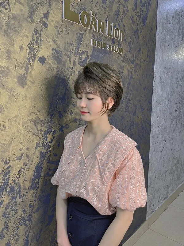 Tóc tomboy có một người phụ nữ dựa vào tường với hai tay trong túi