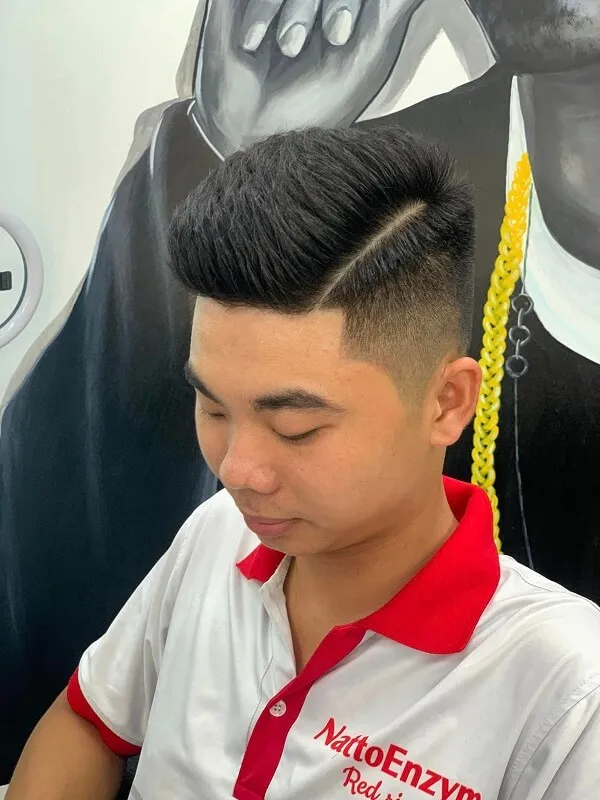 Tóc undercut nam có một chàng trai trẻ đang nhìn vào điện thoại di động của mình