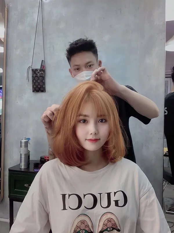 Tóc uốn chữ có một người phụ nữ đang bị cắt bởi đàn ông
