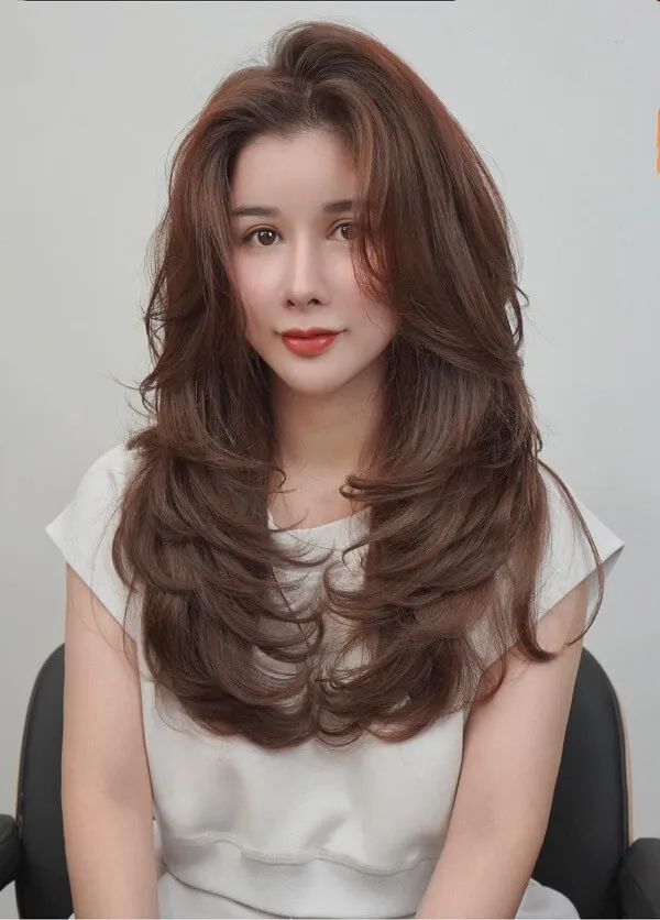 Tóc uốn chữ có một người phụ nữ đang ngồi trên ghế với mái dài