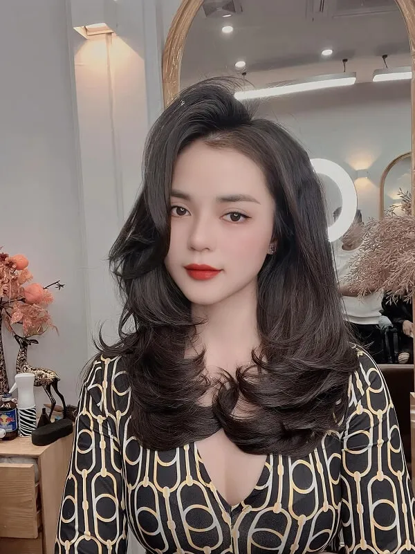 Tóc uốn chữ tầng người phụ nữ trẻ với mái đen dài mặc váy in da báo