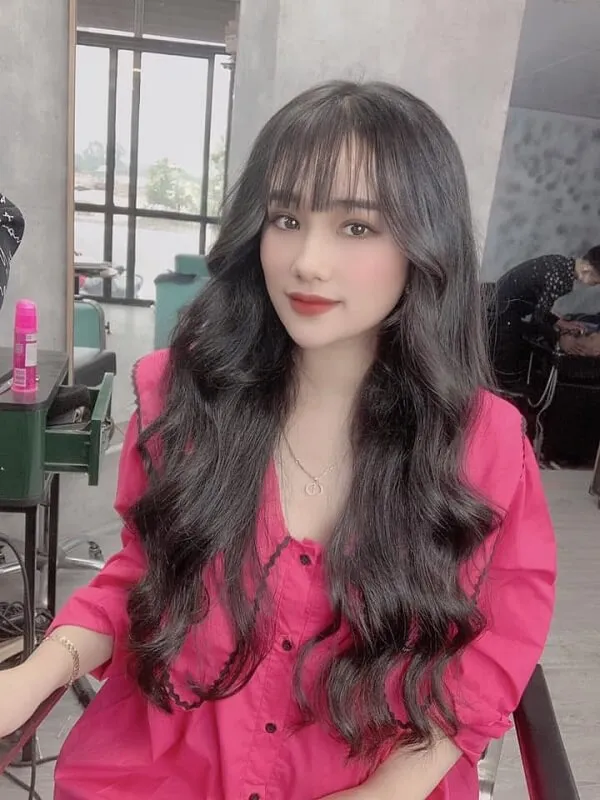 Tóc dài uốn xoăn sóng nước có một người phụ nữ đang ngồi trên ghế với mái