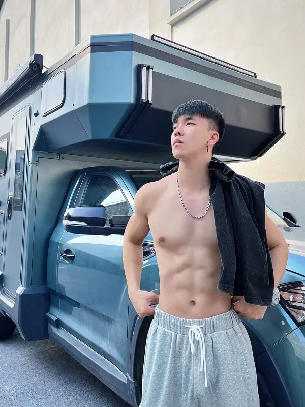 Trai đẹp trung quốc múi có một người đàn ông không mặc áo đứng trước chiếc xe tải màu xanh