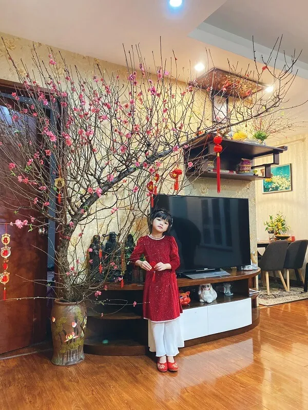 Có một người phụ nữ đang đứng trước cây