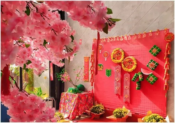 Có một màn hình hoa và đồ trang trí trên bàn màu đỏ