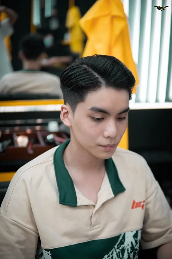 Tóc nam undercut có một chàng trai trẻ ngồi bàn với đĩa thức ăn