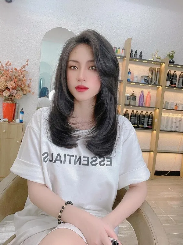 Uốn cụp chữ tóc ngắn có một người phụ nữ ngồi trên ghế mặc áo phông nói những điều cần thiết