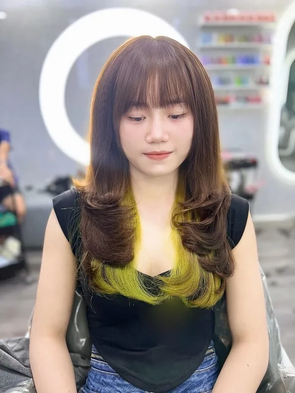 Uốn cụp chữ tóc ngắn có một người phụ nữ đang ngồi xuống với điện thoại di động