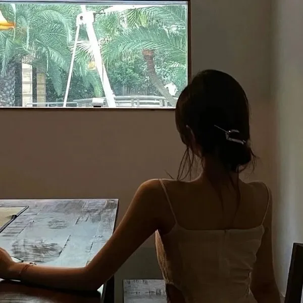 Có một người phụ nữ đang ngồi bàn với máy tính xách tay